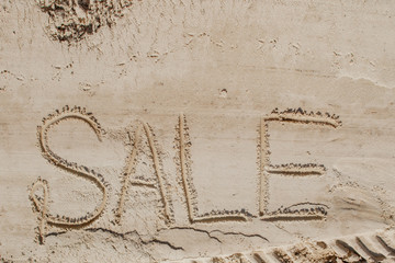 The word sale is painted on the sand. Beach background. View from above. The concept of summer, summer kanikkuly, vacation, holydays.
