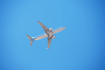 Airplane flying in clear cloudless blue sky