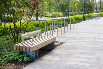 Macro photo of a modern wooden bench in the city park. City improvement, urban planning, public...