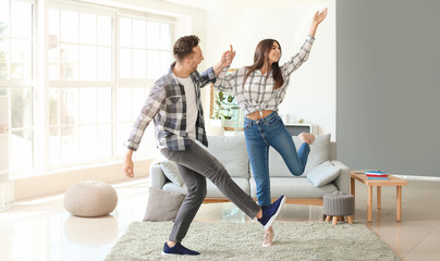 Fototapeta premium Happy young couple dancing at home