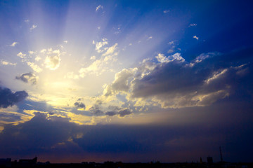 Silhouette of city under colorful sky with cumulus clouds at sunset