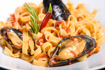 Homemade pasta with mussels, sprinkle with chopped parsley and basil. Delicious of pasta with mussel