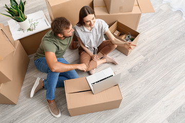 Young couple with laptop planning design of their new house