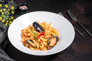 Homemade pasta with mussels, sprinkle with chopped parsley and basil. Delicious of pasta with mussel