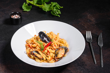 Homemade pasta with mussels, sprinkle with chopped parsley and basil. Delicious of pasta with mussel