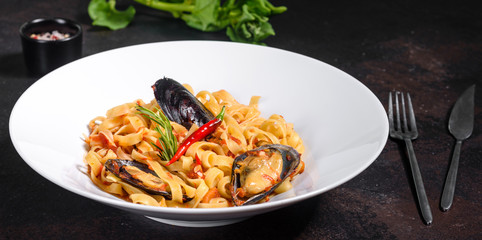Homemade pasta with mussels, sprinkle with chopped parsley and basil. Delicious of pasta with mussel