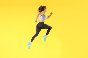 Fototapeta na wymiar Running sporty woman on color background