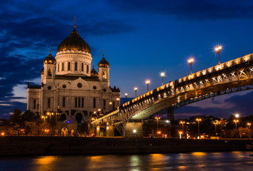 Fototapeta na wymiar Illuminated Cathedral of Christ the Savior framed with old style street lights of Patriarchy Bridge at night.