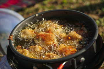 Perkedel jagung or bakwan jagung, corn fritters that is in fry in Portable stove. Indonesian cuisine.