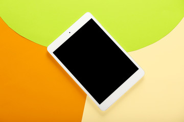 Modern tablet computer on color background