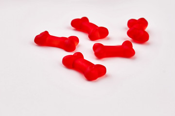 Red jelly candies in shape of bones. Gummy bones sweets of red color. Vibrant jelly treats.