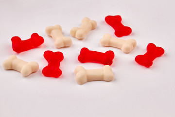 Colorful jelly bones on white background. Red and white gummy candies in shape of bones. Junk food concept.