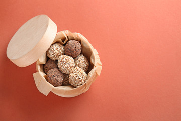 Box with tasty sweet truffles on color background