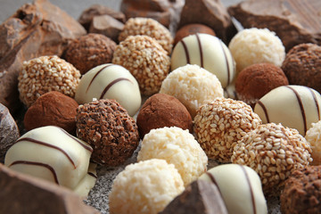 Tasty sweet truffles with chocolate on grey background