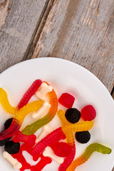 Top view on plate with jelly candies. Multicolored gummy sweets for Halloween holiday. Delicious treats for kids.