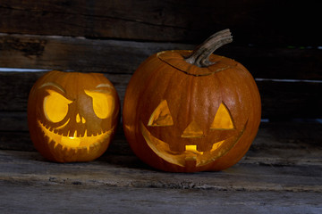 Two Halloween pumpkins on wooden background. Halloween pumpkin Jack-O-Lantern heads. Halloween decoration ideas.