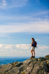 Silhouette of young woman climbing a rock.