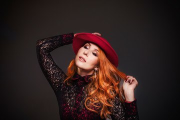 Autumn mood of beauty: smiling woman with red hat, studio portrait