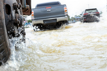 Cars driving on a flooded road, The broken car is parked in a flooded road. .