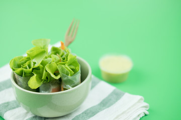 Salad rolls in bowl and salad dressing