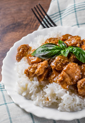 Chicken Breast with sauce and Rice in white plate on a wooden table background