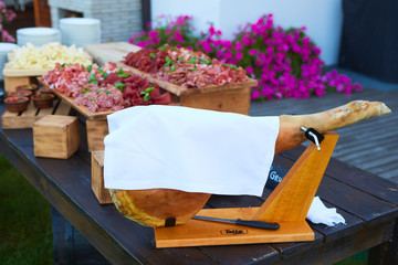 Italian dry-cured ham prosciutto on table. Toned image. Selective focus point