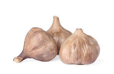 Fototapeta premium Unpeeled bulbs of black garlic on white background