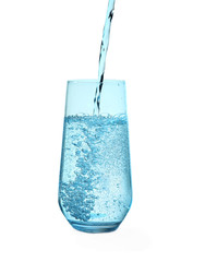 Pouring water from bottle into glass against blue background. Refreshing drink