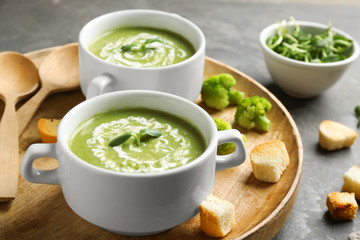 Bowls of delicious broccoli cream soup with microgreens served on tray