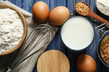 Flat lay composition with fresh ingredients for delicious homemade cake on blue wooden table
