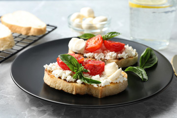 Tasty fresh tomato bruschettas on grey marble table