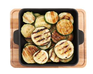 Grill pan with delicious zucchini slices on white background, top view