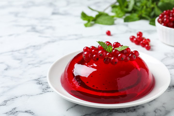 Delicious fresh red jelly with berries and mint on marble table