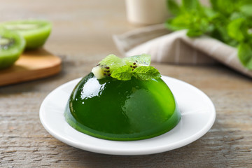 Delicious fresh green jelly with kiwi slices and mint on wooden table