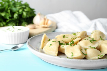 Delicious cooked dumplings on light blue wooden table