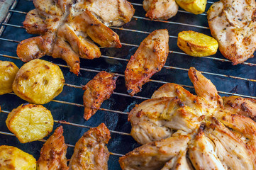 Roasted Potatoes and Chicken Slices on Stainless Steel Cooking Grid. Grilled Chicken Breast with Slices Made for Marinade to Penetrate the Meat Better, and Ensure Chicken Cooked Evenly.