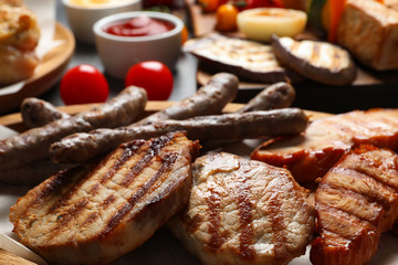 Barbecued meat and vegetables on table, closeup