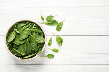 Fresh green healthy spinach on white wooden table, flat lay. Space for text