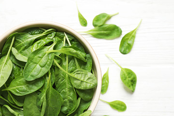 Fresh green healthy spinach on white wooden table, top view. Space for text
