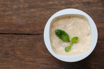 Prune yogurt with pepper mint topping good healthy and delicious in plastic glass on wood table background
