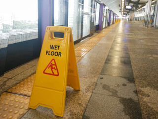 The warning signs wet floor on the sky train station to remind people to walk safely.