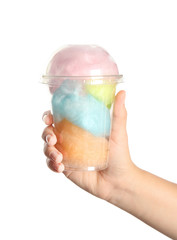 Young woman holding plastic cup with cotton candy on white background, closeup