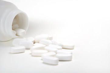Medicine concept.  Pills, tablets and bottle on white background. Pharmacy theme. Top view with copy space.