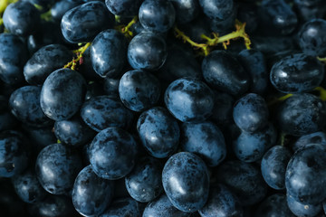 Fresh ripe juicy black grapes as background, closeup view