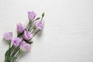 Beautiful Eustoma flowers on white wooden table, top view. Space for text