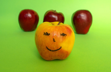 Happy smiling apple face on green background.