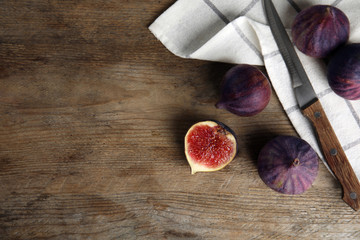 Ripe figs on wooden table, flat lay. Space for text
