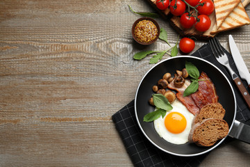 Tasty breakfast with fried egg served on wooden table, flat lay. Space for text