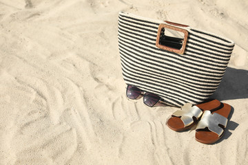 Stylish beach accessories on sandy sea shore, space for text