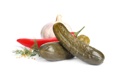 Pickled cucumbers with products on white background